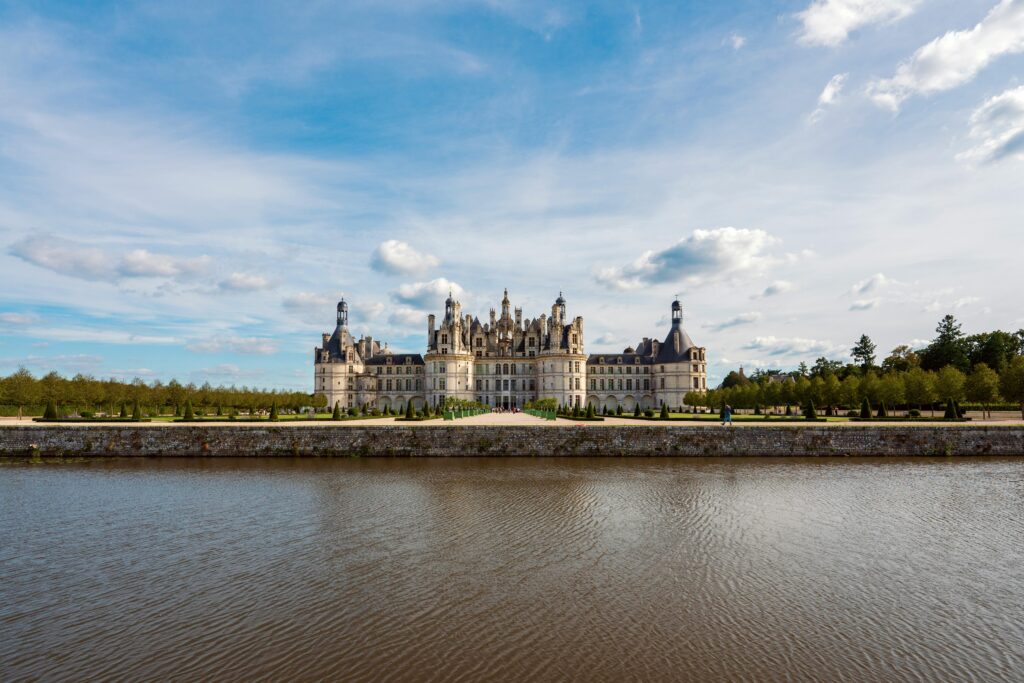 Majestic Château de Chambord with a picturesque reflection on a sunny day in France.